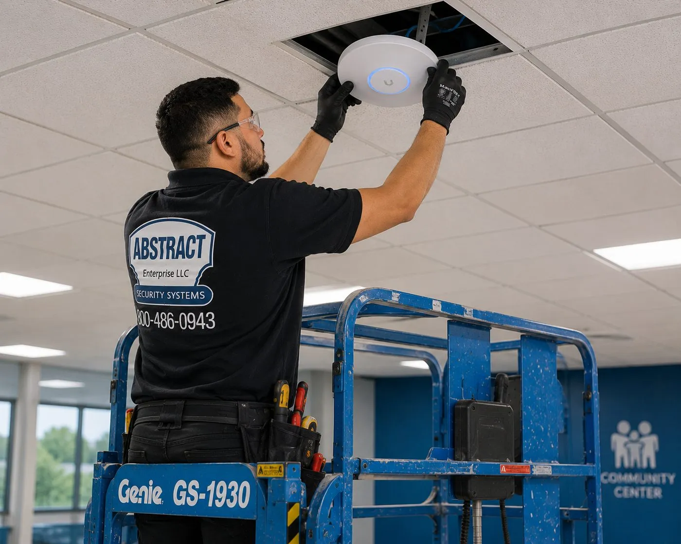 Ceiling work from a scissor lift — Long Island fiber and network installation Technician on a scissor lift seating a ceiling-mounted wireless access point fed from above for a Long Island fiber optic installation