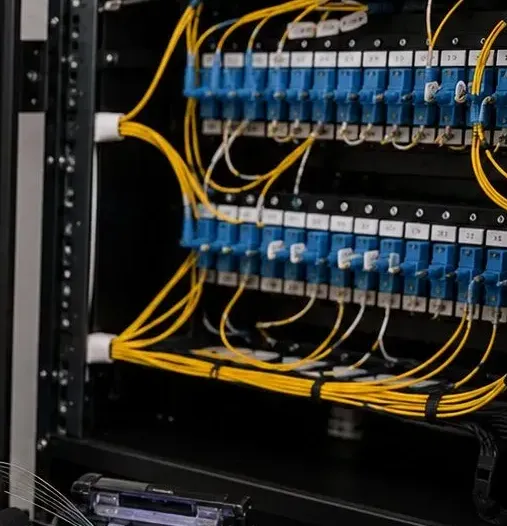 Blue SC adapter panels and yellow jumpers in a rack, New Springville, Staten Island fiber patching Rack of blue SC adapter panels with numbered labels and yellow single-mode jumpers dressed down both sides, fiber patching for New Springville, Staten Island installations