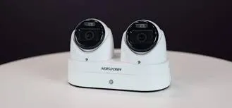 Two white Hikvision turret cameras side by side, product photo for Ulster County Hikvision turret cameras for Ulster County houses: two white turret cameras side by side on a white stand, product photo