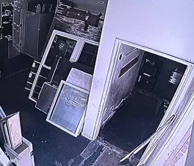 Night camera tile of a back room and open door โ Bronx Smart PSS playback example Smart PSS support Bronx example photo: a black-and-white night camera tile of a cluttered back room with stacked boards and an open door