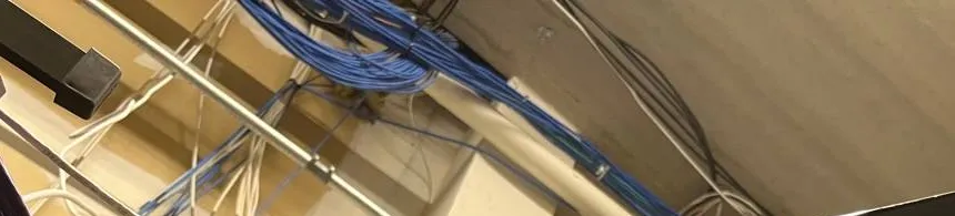Throgs Neck, Bronx Sonos installation reference photo: bundles of blue and white network cable fanning out beneath a ceiling deck beside a metal conduit