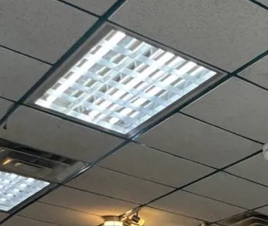Light panel and slot vent in a drop ceiling — AESS reference photo for Sonos work on the Upper West Side, Manhattan Upper West Side, Manhattan Sonos reference photo: lay-in light panel above a slotted return vent in a grey-gridded drop ceiling