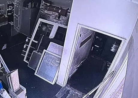 Greyscale storeroom view with open doorway — Uniview camera installation Dutchess County recorder example Greyscale camera tile of a storeroom with stacked frames and an open doorway, as seen in a Dutchess County Uniview recorder