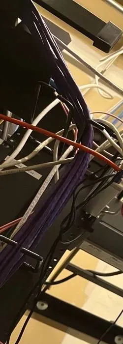 Purple patch cable bundle down an equipment rack â Manhattan Uniview recorder room reference Manhattan Uniview installation reference photo: a thick bundle of purple network cables running down the side of a black equipment rack, with white and orange cables crossing it
