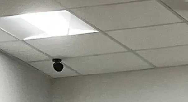 Black eyeball camera in a ceiling corner below a light panel — Nassau County Uniview installation example Black eyeball camera in a ceiling corner below a light panel — Uniview camera installation Nassau County example photo