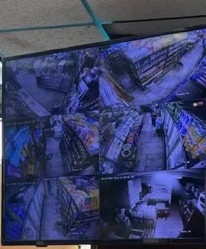 Monitor grid of overhead store aisle views — Nassau County Uniview storefront installation example Monitor showing a grid of overhead store aisle camera views — Uniview camera installation Nassau County retail example