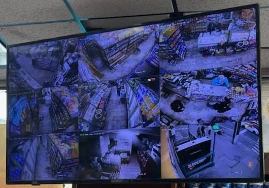 Video wall installation Long Island example photo: close-up of a hung display split into twelve camera tiles showing shop aisles and a counter